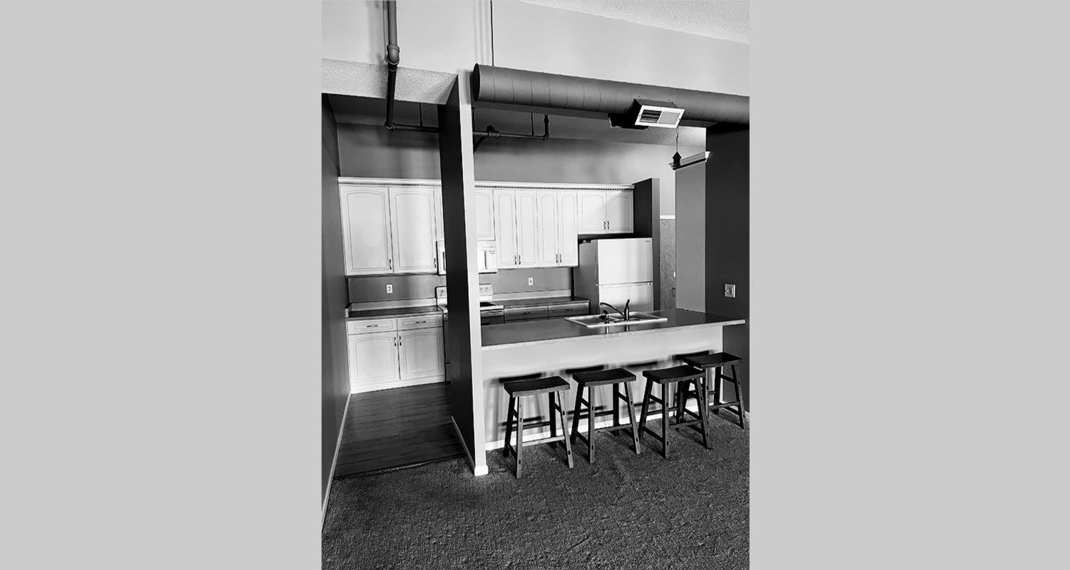 Open kitchen island with bar stools looking into kitchen area behind island