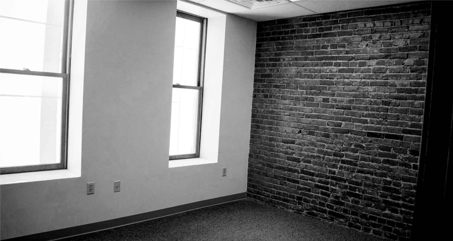Inner office room with exposed brick wall and windows